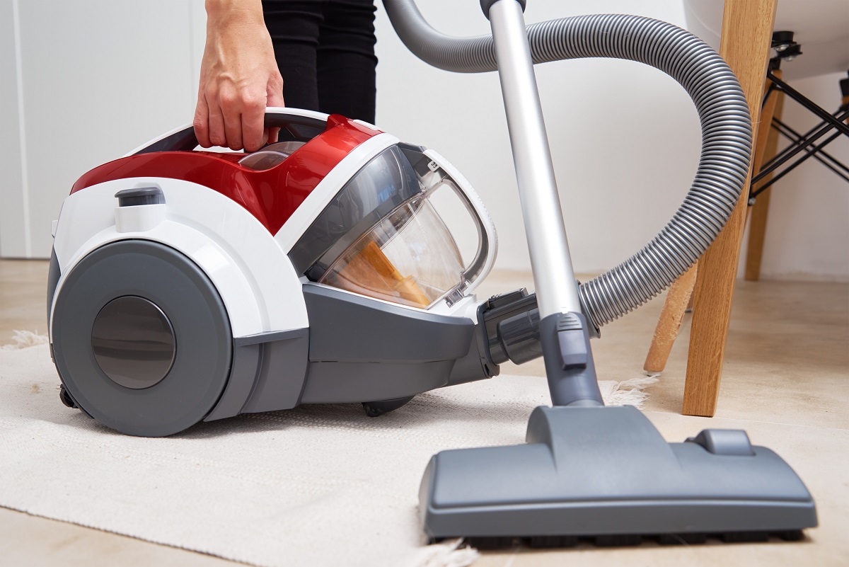 Woman use vacuum cleaner at the floor